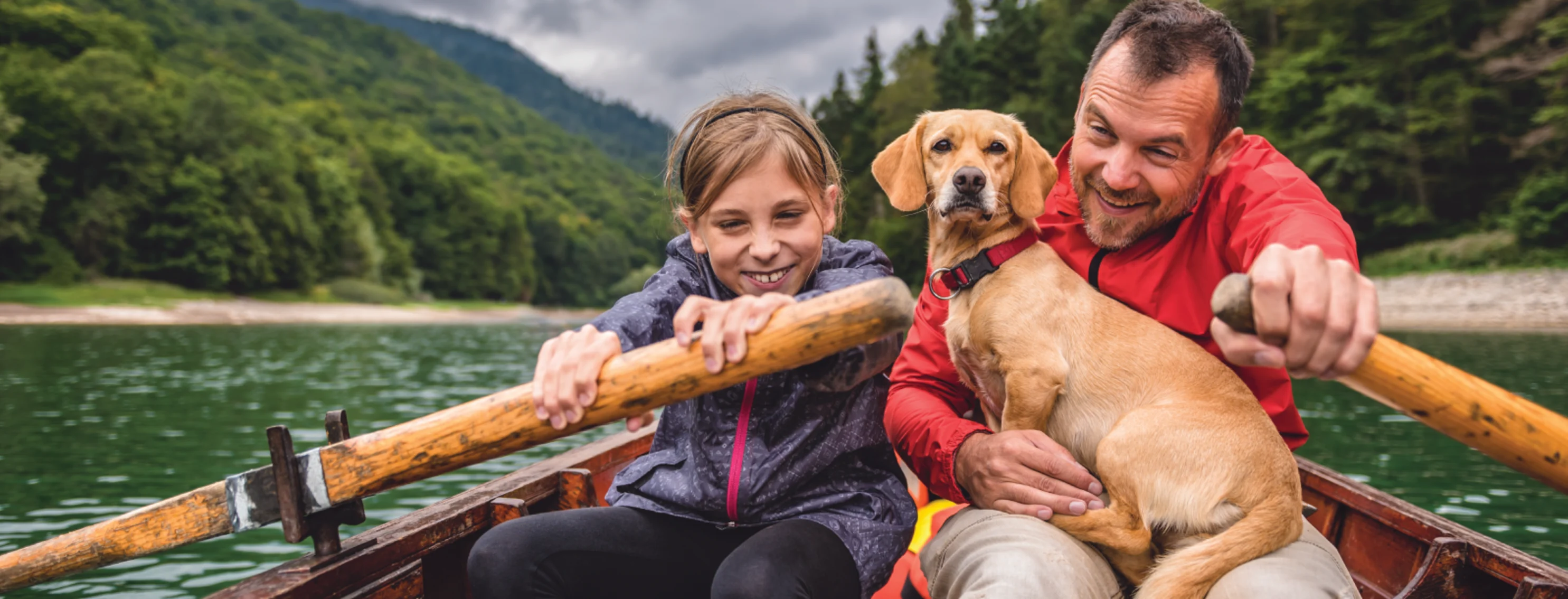 Outdoor dog in boat with family rowing